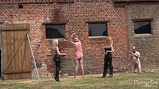 Dominatrix punishes slaves outdoors